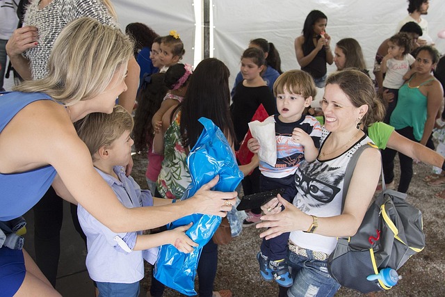 Woman with child giving a package to another woman with child
